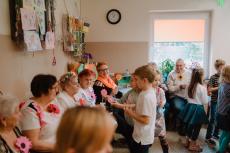 Powiększ zdjęcie: 12.	Dzieci ze Świetlicy Pod Aniołami wręczają Seniorom w Komorowicach upominki własnoręcznie przygotowane z okazji Dni Seniora