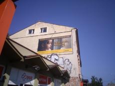 Powiększ zdjęcie: ) bilboard o rozmiarach 600 centymetrów na 300 centymetrów umieszczony na budynku w Bielsku-Białej przy ulicy Michałowicza 18,  promujący kampanię społeczną pod nazwą  „Szukam rodziny zastępczej” przedstawiający smutną dziewczynkę przy mokrym od deszczu oknie