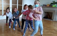Powiększ zdjęcie: Pięć dziewczynek tańczy na sali z panią instruktor