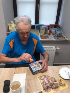 Powiększ zdjęcie: Senior z Dziennego Domu Senior Plus podczas zajęć manualnych wykonuje ikonę techniką decoupage