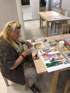 Powiększ zdjęcie: Seniorka z Dziennego Domu Senior Plus podczas zajęć manualnych wykonuje prace techniką kolażu 