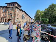 Powiększ zdjęcie: Seniorzy z Klubu Senior Plus z ulicy Jesionowej na wycieczce w Katowicach w tle budynki zabytkowej dzielnicy Nikiszowiec
