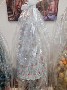 Powiększ zdjęcie: Zdjęcie przedstawia sztuczna białą choinkę z czerwonymi koralikami na brzegach.