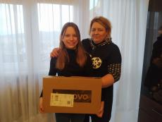 Powiększ zdjęcie: Zdjęcie przedstawia uśmiechniętą dziewczynę i jej opiekunkę zastępczą, które trzymają pudełko z laptopem